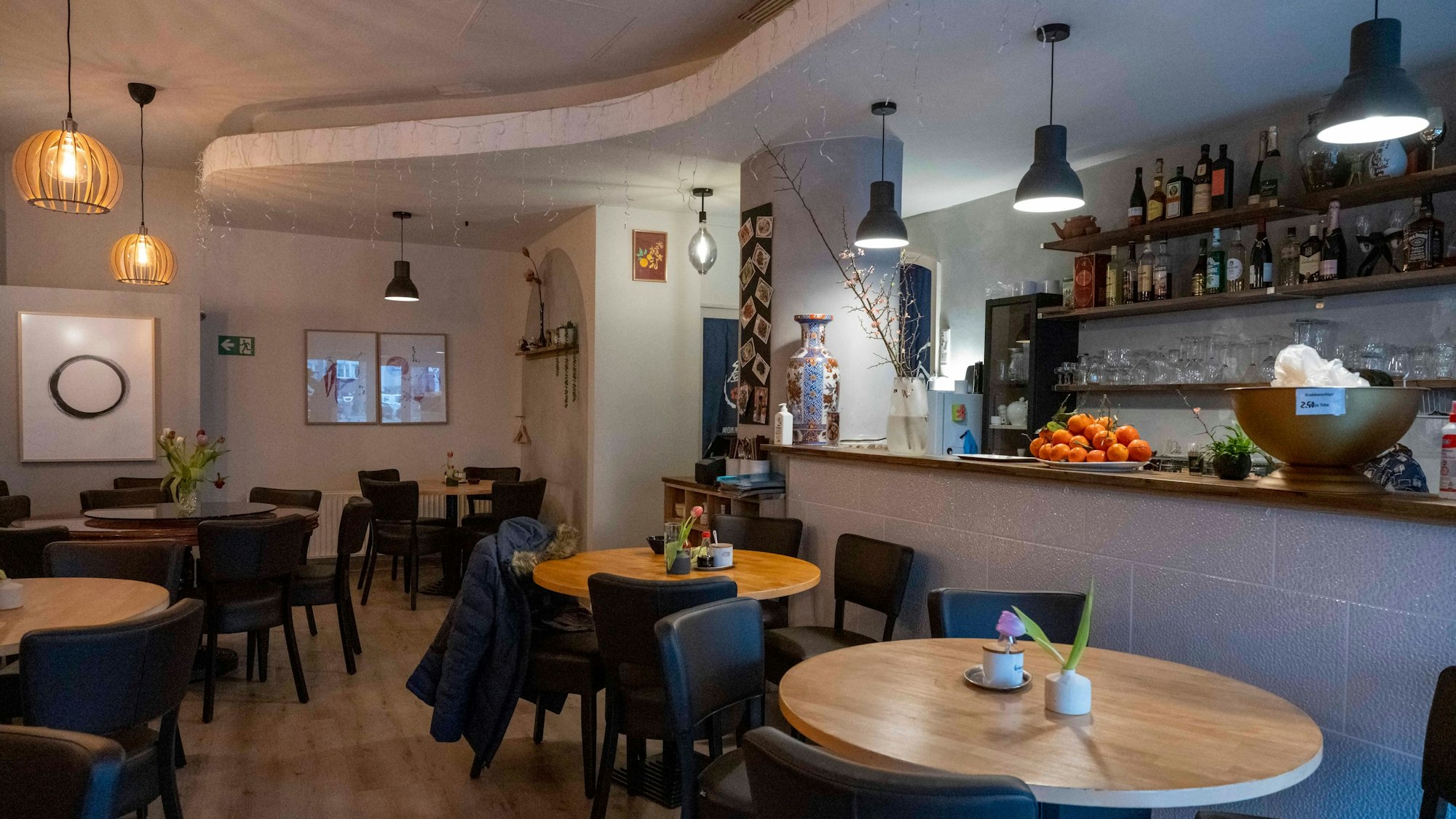 Runde Tische und gemütliche Stühle stehen im Innenraum des Restaurants Lai de Hao.