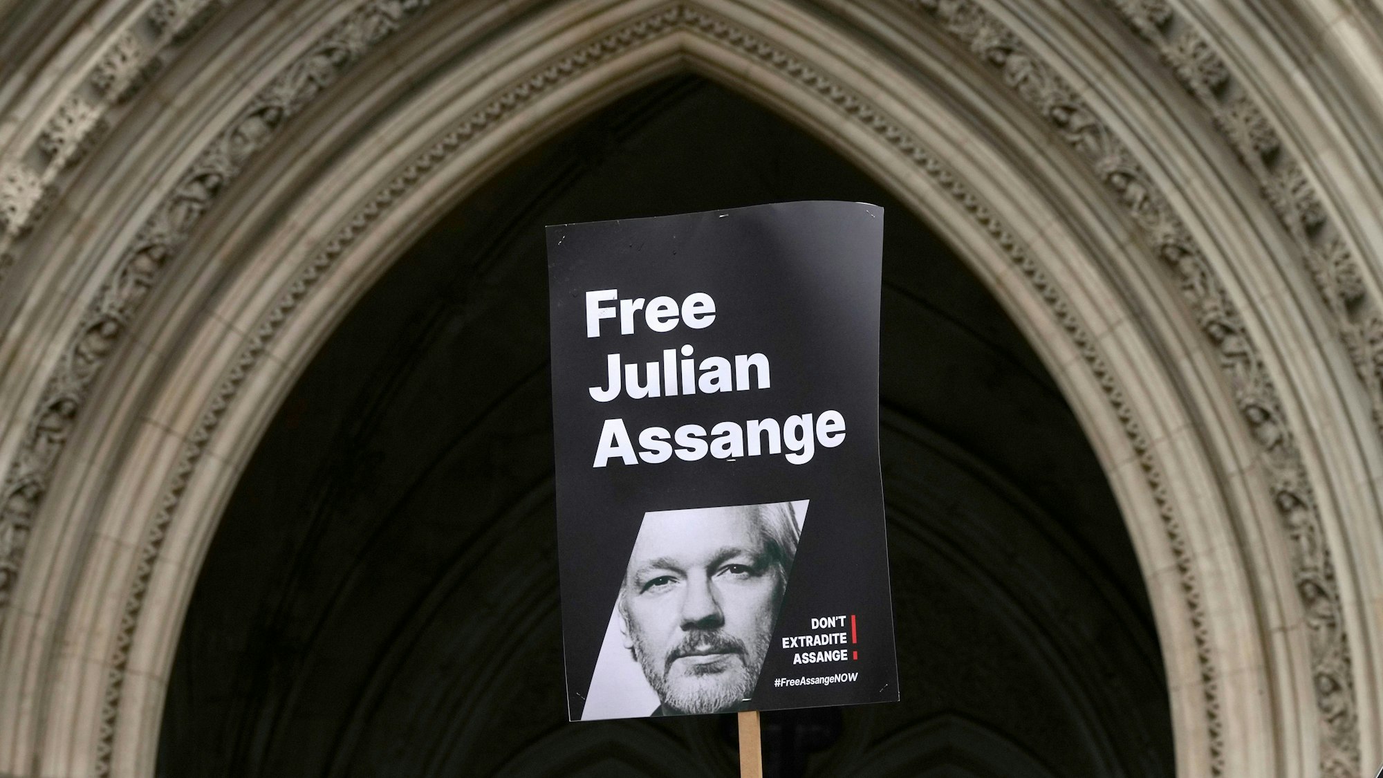 Ein Transparent, mit dem Konterfei von WikiLeaks-Gründer, Julian Assange, wird vor dem Royal Courts of Justice in London hochgehalten.