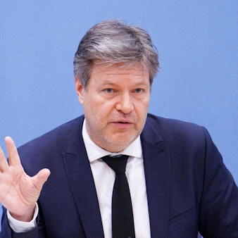 Robert Habeck (Bündnis 90/Die Grünen), Bundesminister für Wirtschaft und Klimaschutz, artikuliert mit der rechten, offenen Hand vor einem blauen Hintergrund.