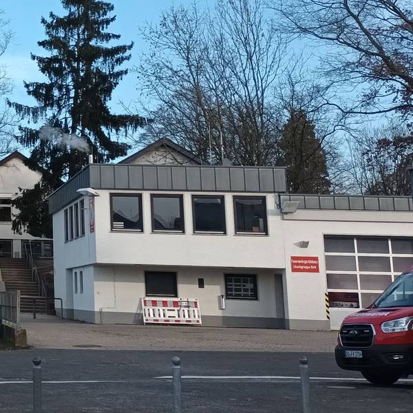 Zwei Gebäude, im Vordergrund ein Feuerwehrauto