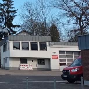 Zwei Gebäude, im Vordergrund ein Feuerwehrauto