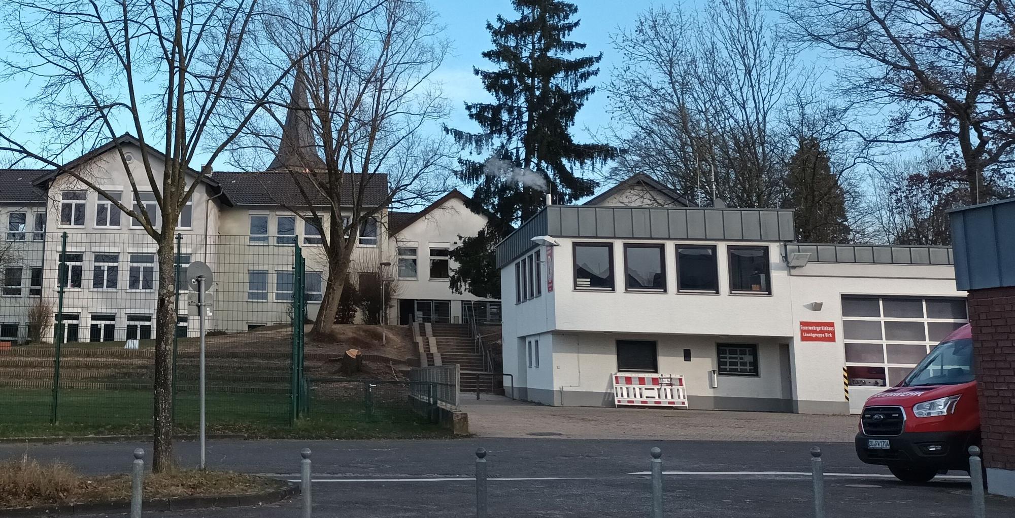 Zwei Gebäude, im Vordergrund ein Feuerwehrauto