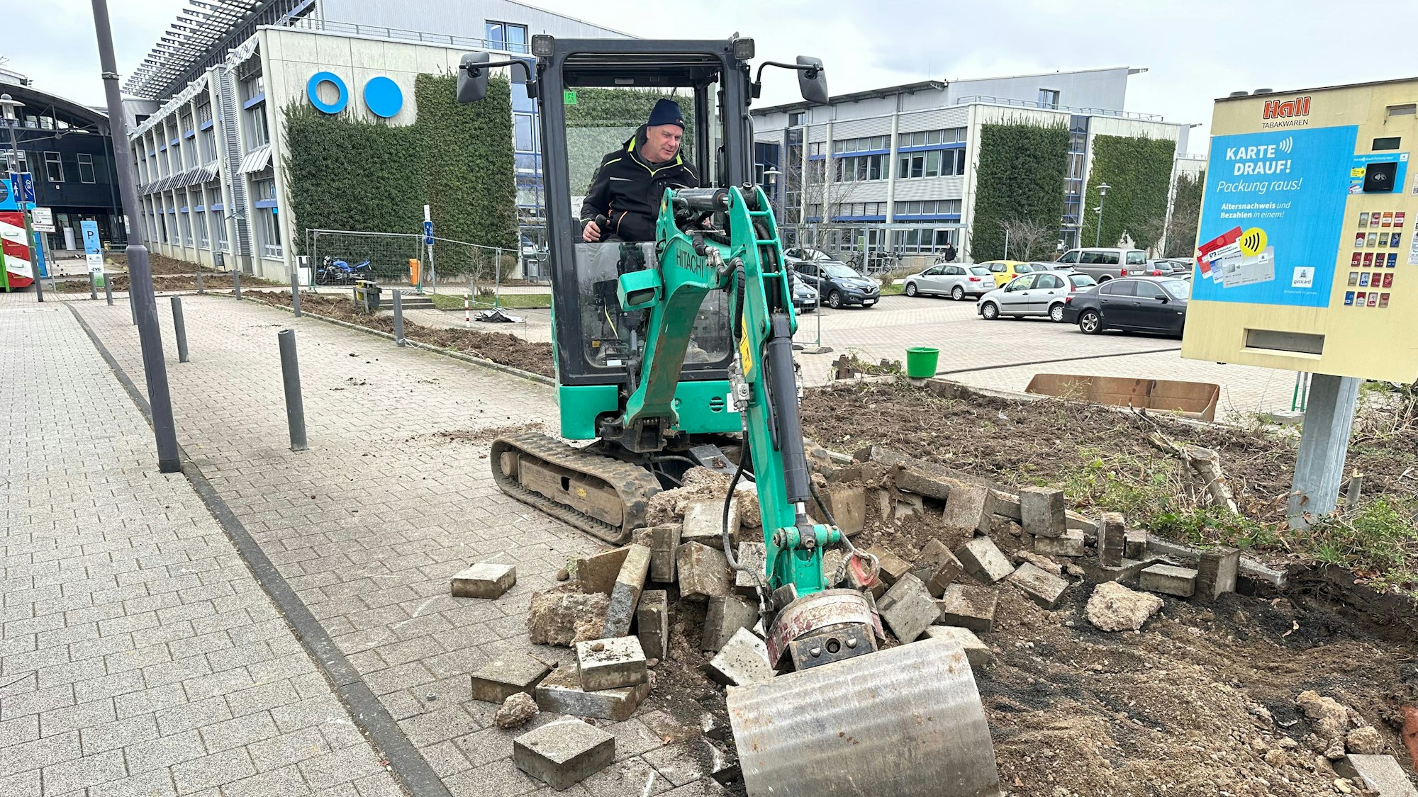 Ein Minibagger reißt das Pflaster des alten Fahrradabstellplatzes auf..