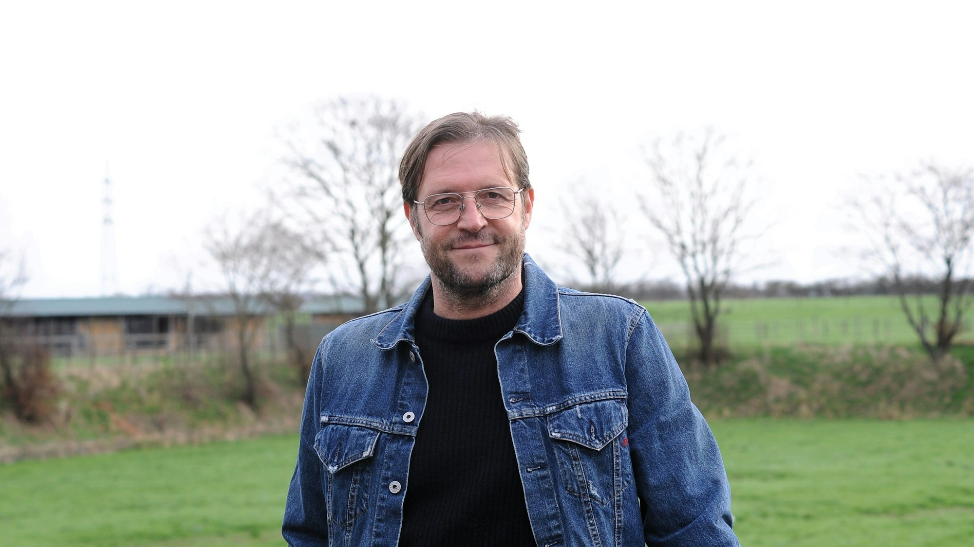 Ein Mann steht vor einem Fußballplatz.