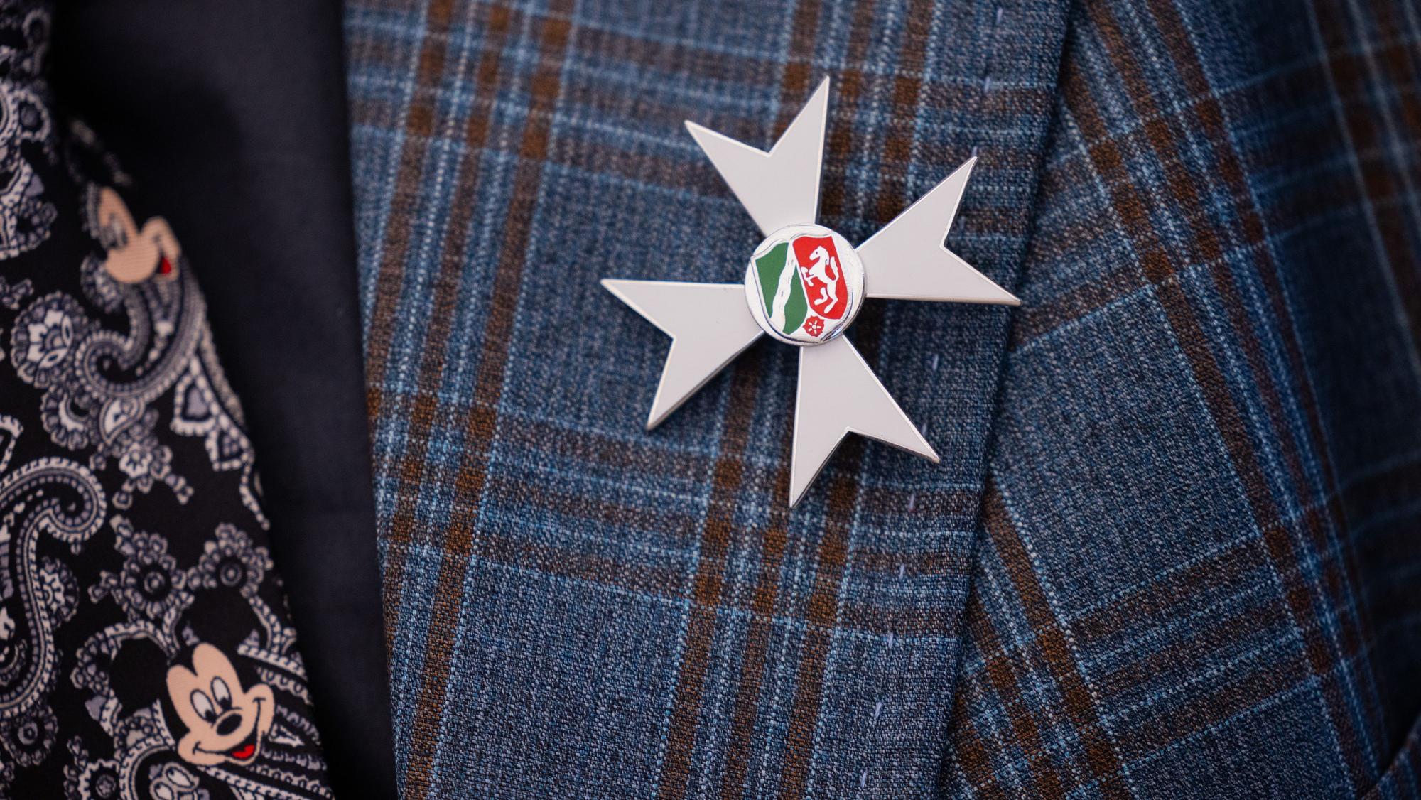 Die Auszeichnung ist am Jacket eines Geehrten nach der Verleihung des Landesverdienstordens in der Staatskanzlei zu sehen.