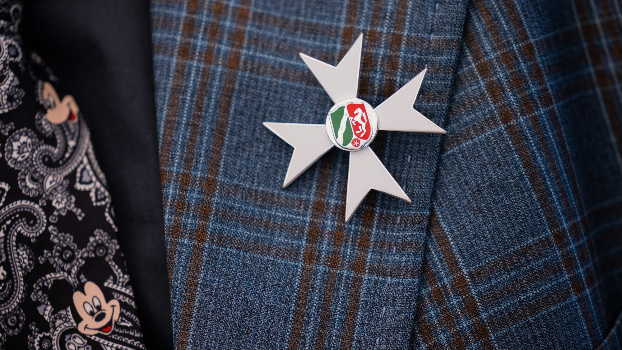 Die Auszeichnung ist am Jacket eines Geehrten nach der Verleihung des Landesverdienstordens in der Staatskanzlei zu sehen.