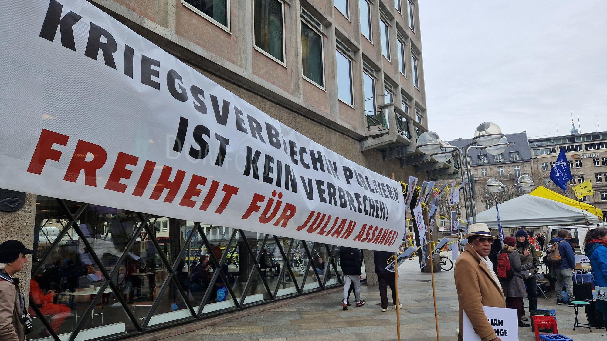 Auf einem Plakat steht „Kriegsverbrechen publizieren ist kein Kriegsverbrechen“.