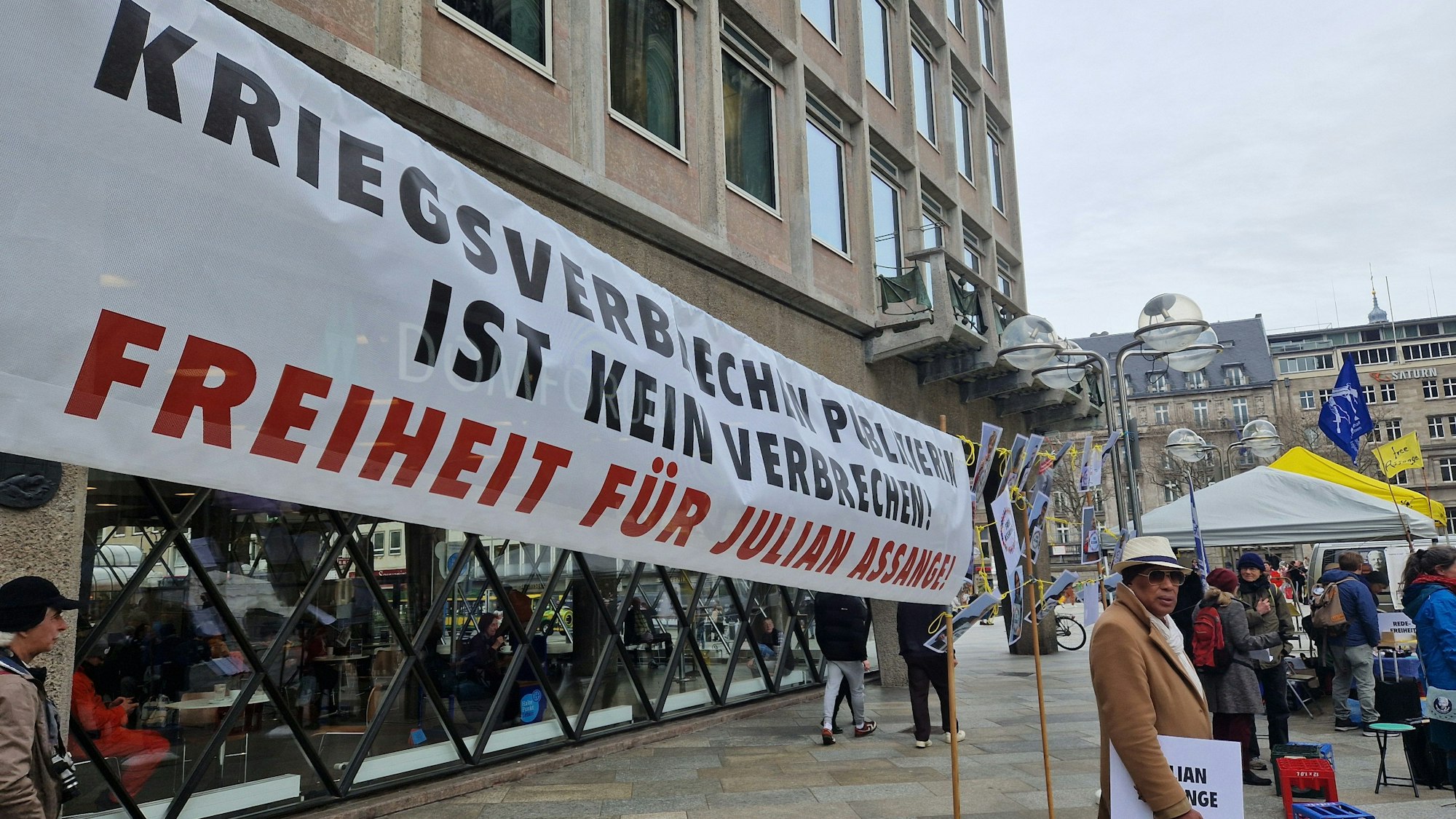 Auf einem Plakat steht „Kriegsverbrechen publizieren ist kein Kriegsverbrechen“.