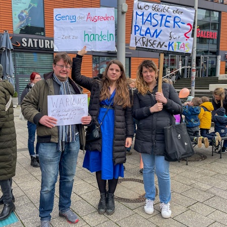 Eltern mit Plakaten.