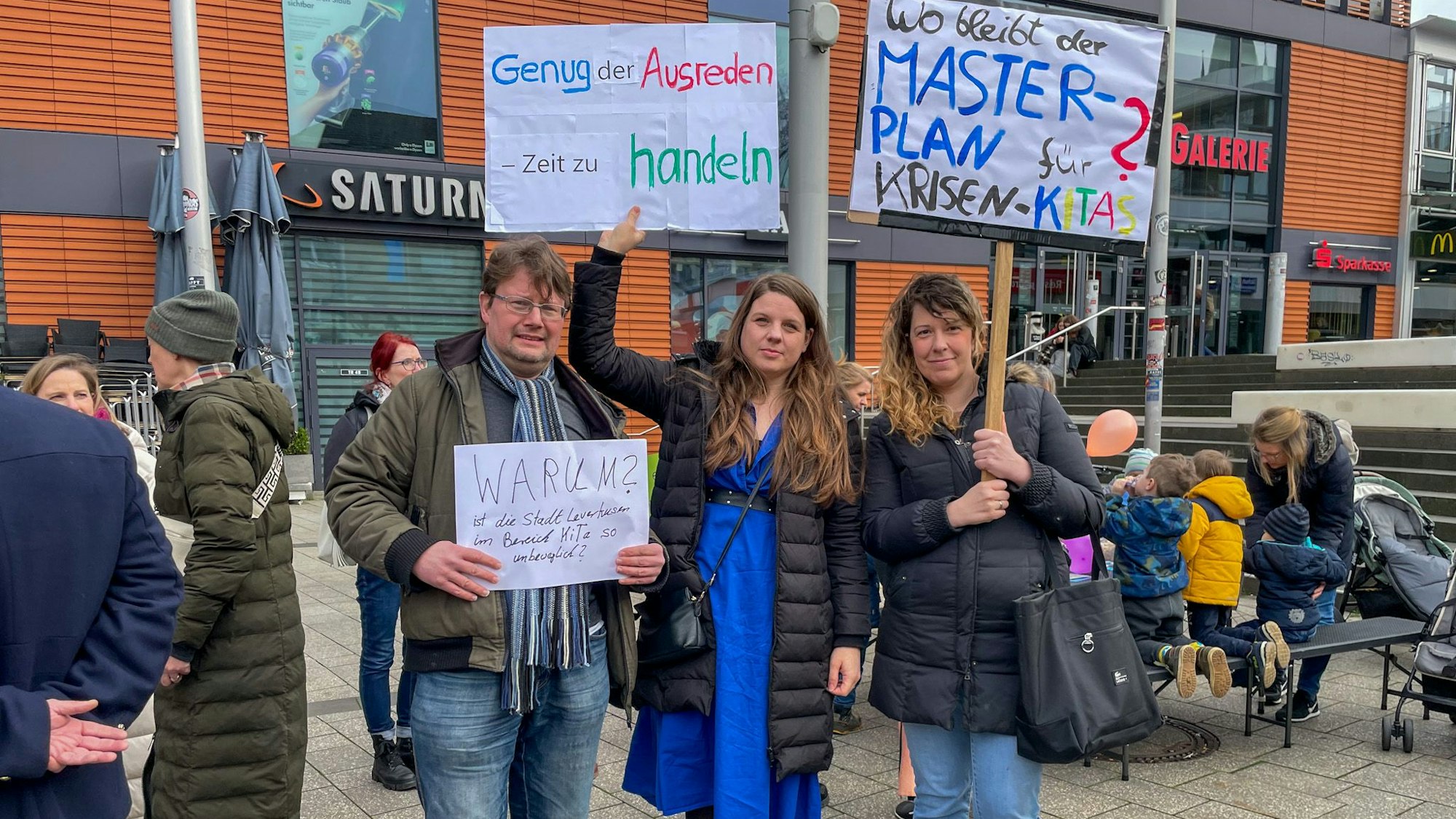Eltern mit Plakaten.