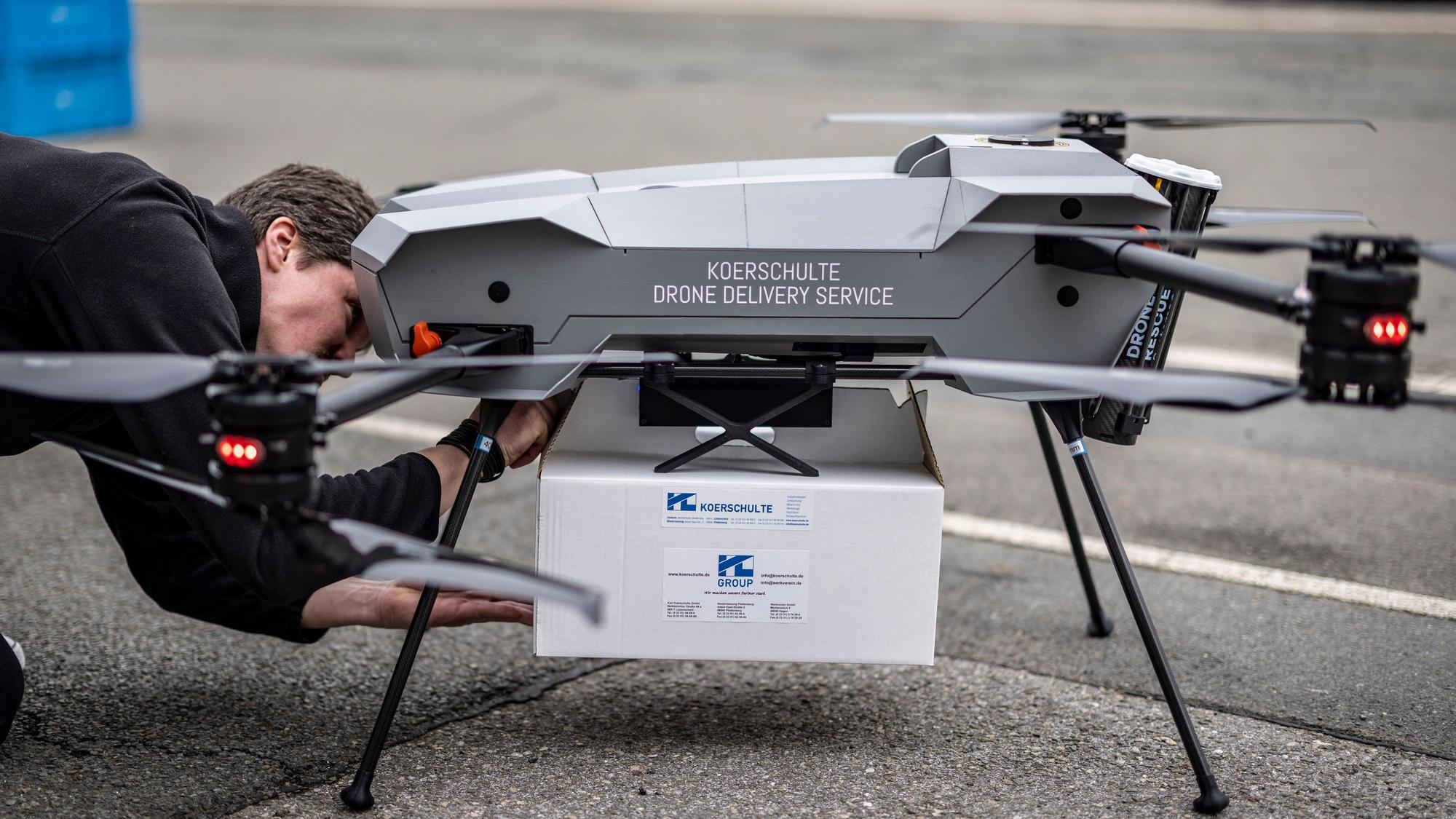 Ein Techniker befestigt das zu liefernde Paket an einer Drohne vom Hersteller Third Element Aviation aus Bielefeld.