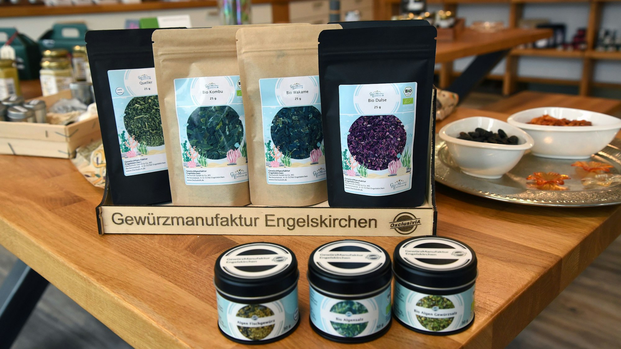 Nachfüllpackungen mit Gewürzen stehen hinter mehreren Dosen mit Gewürzen auf einem Tisch.