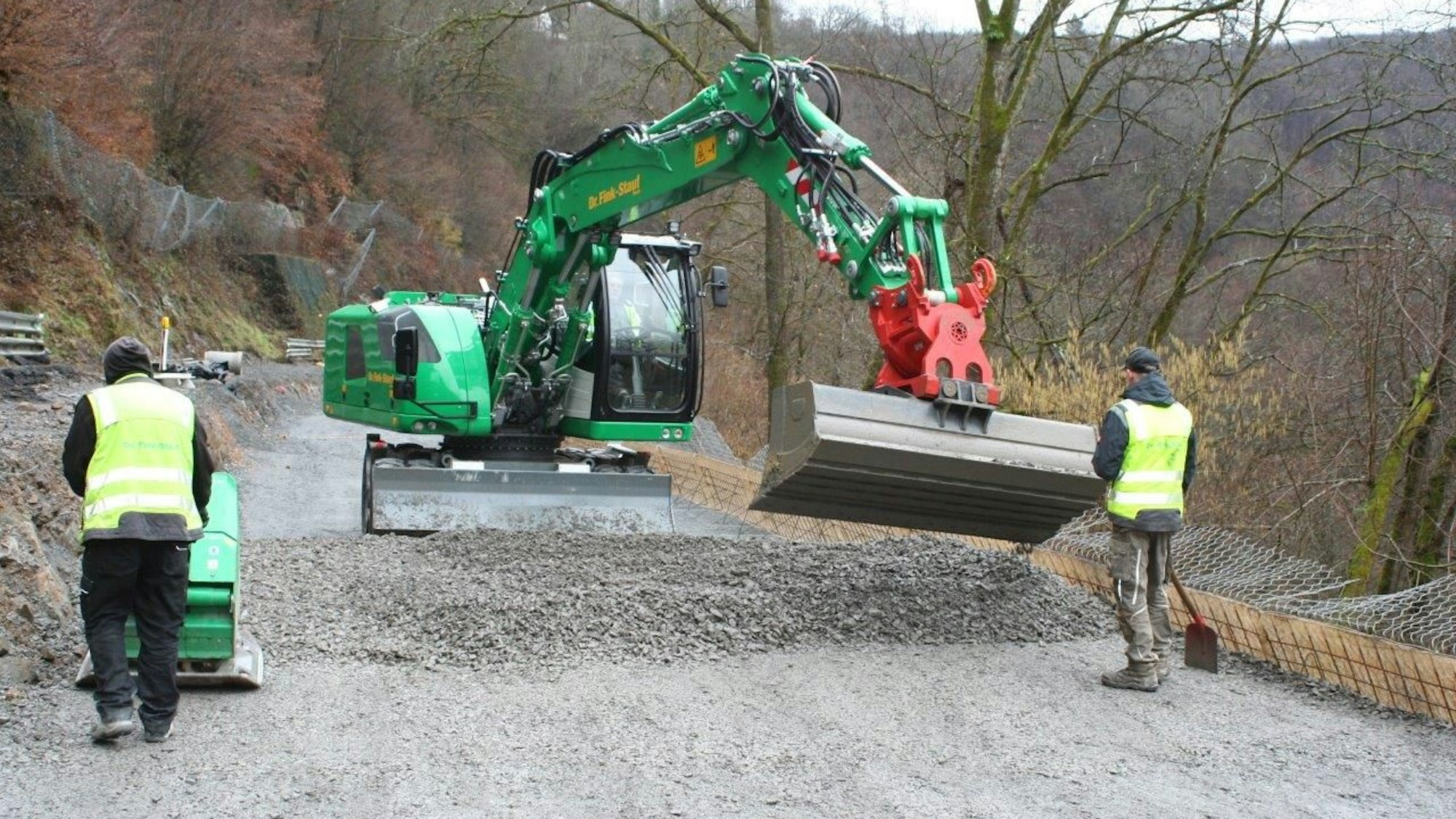 Baggerschaufel setzt an Schotterhaufen an.