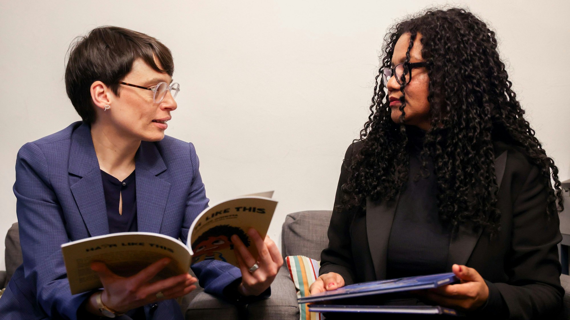 Zwei Frauen mit Büchern in der Hand.