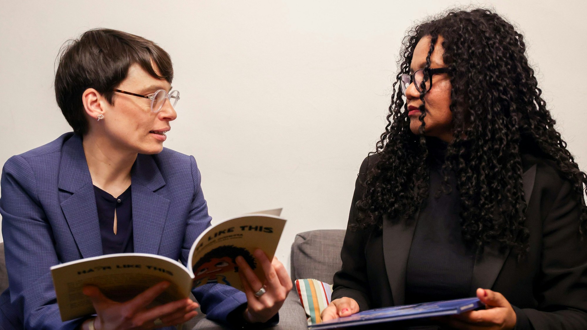 Zu sehen sind die NRW-Gleichstellungsministerin Josefine Paul und Glenda Obermuller, Leiterin der Theodor Wonja Michael Bibliothek in der Seitenansicht.