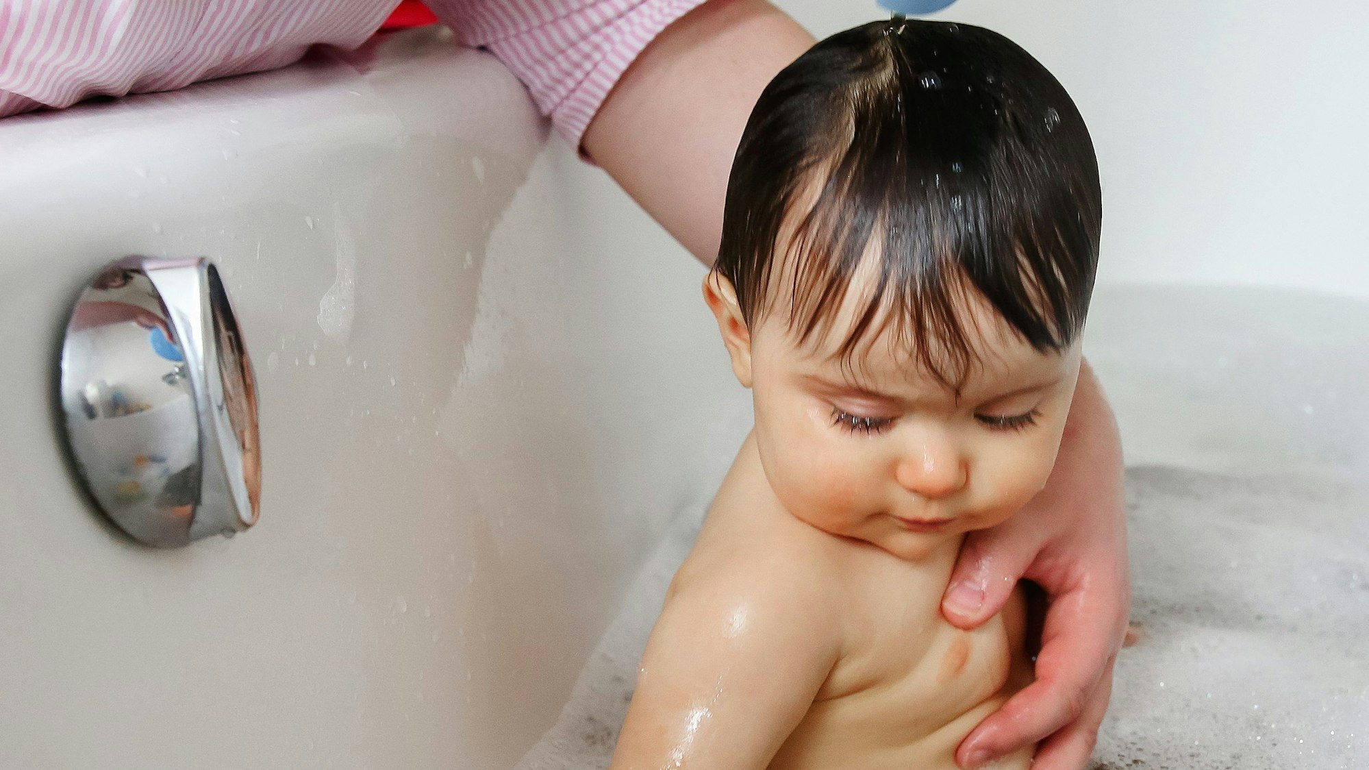 Ein Kleinkind sitzt in einer Badewanne