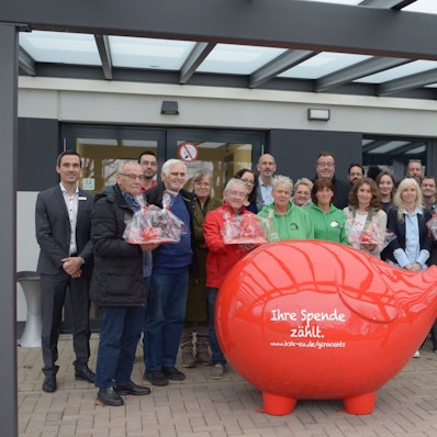 Vertreter von Vereinen und Kreissparkasse stehen für ein Gruppenfoto hinter einem überdimensionalen roten Sparschwein mit der Aufschrift „Ihre Spende zählt“.