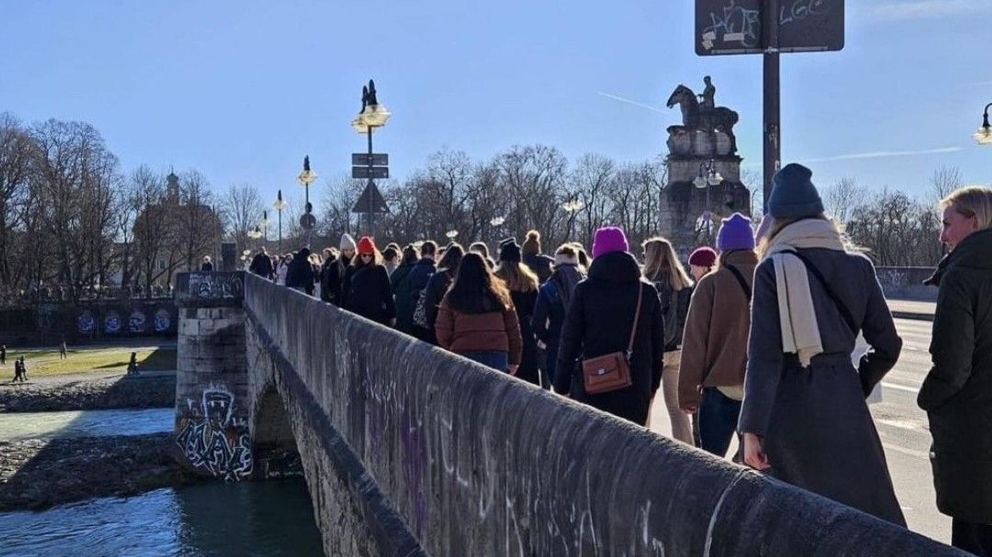 Frauen, die über eine Brücke laufen.