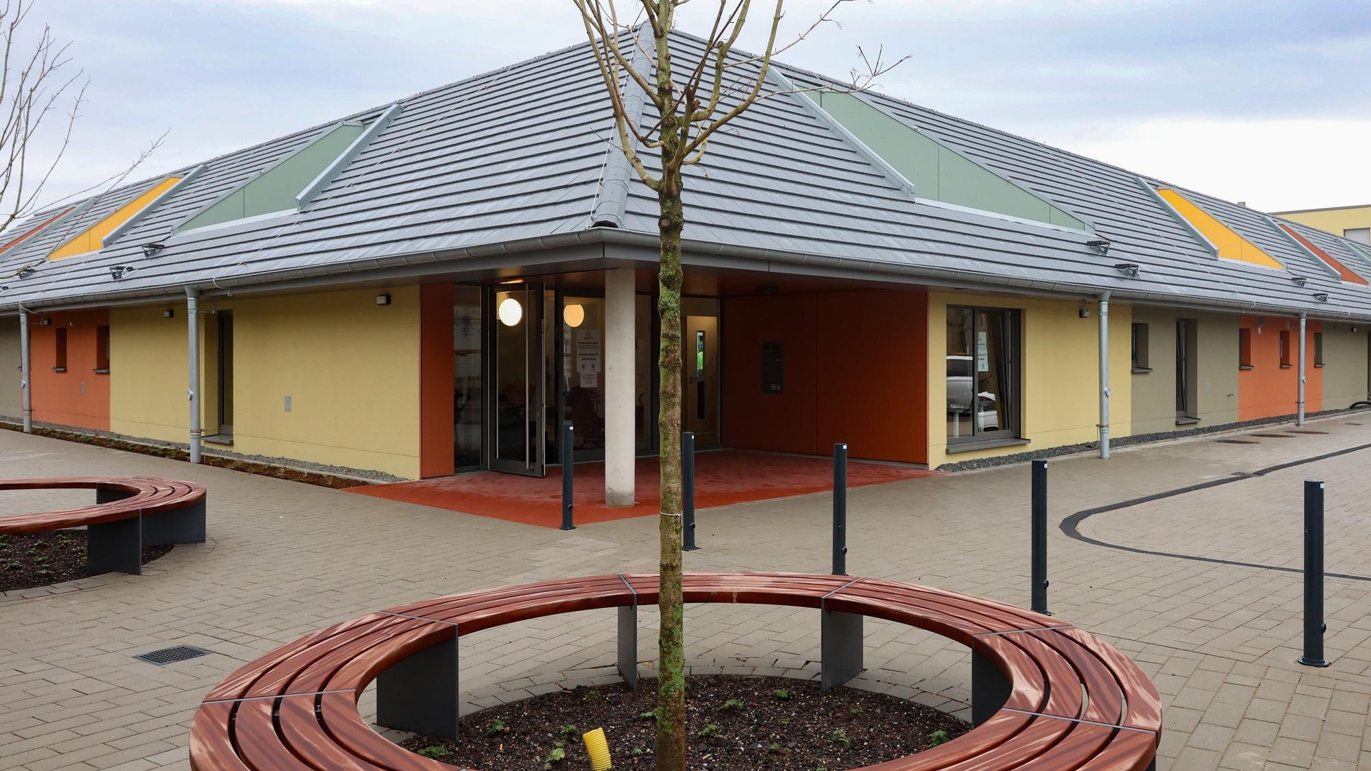 Zu sehen ist die neue Kindertagesstätte von außen. Im Vordergrund ist ein kleiner Baum zu sehen.