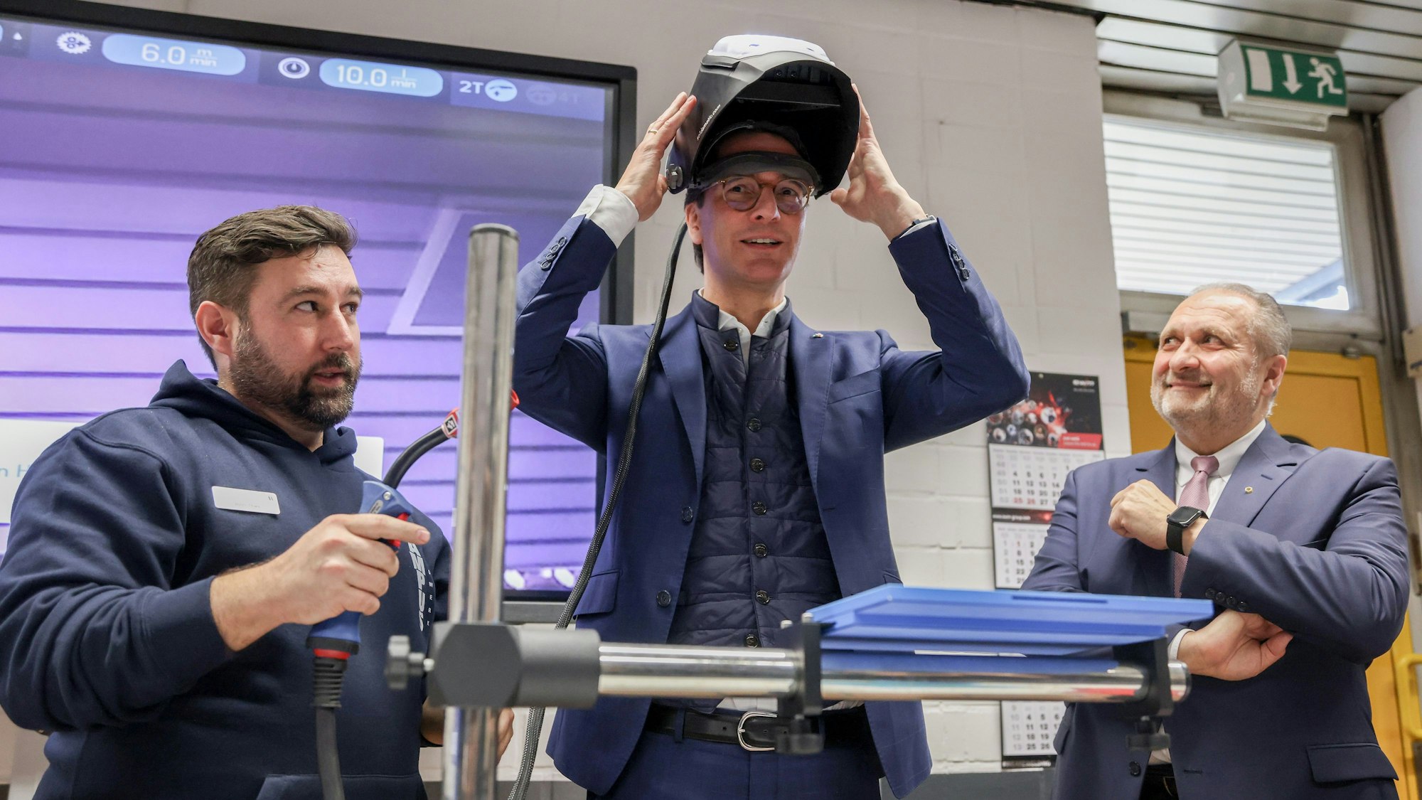 Köln: NRW-Ministerpräsident Hendrik Wüst tourt durch das Rheinland und besucht den Ausbildungscampus der Handwerkskammer in Köln - Ausbilder Björn Thies mit Wüst und Hans Peter Wollseifer, Präsident Handwerkskammer Köln.