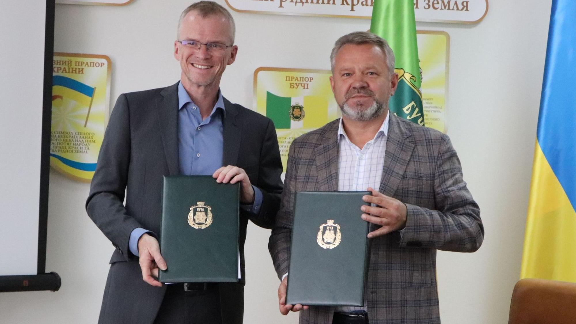 Bergisch Gladbachs Bürgermeister Frank Stein und Butschas Bürgermeister Anatolii Fedoruk halten Mappen mit der unterschrieben Städtepartnerschaftsurkunde in den Händen.
