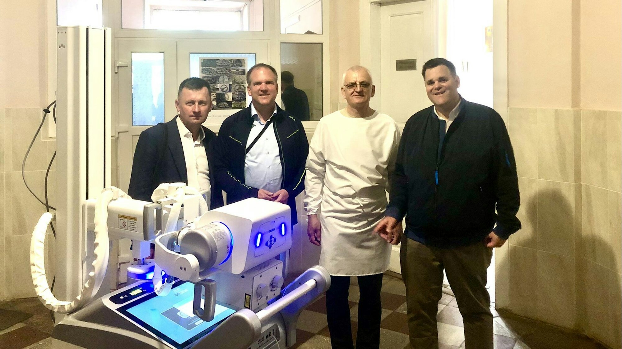 Vier Männer in einem ukrainischen Krankenhaus hinter einem Röntgengerät.