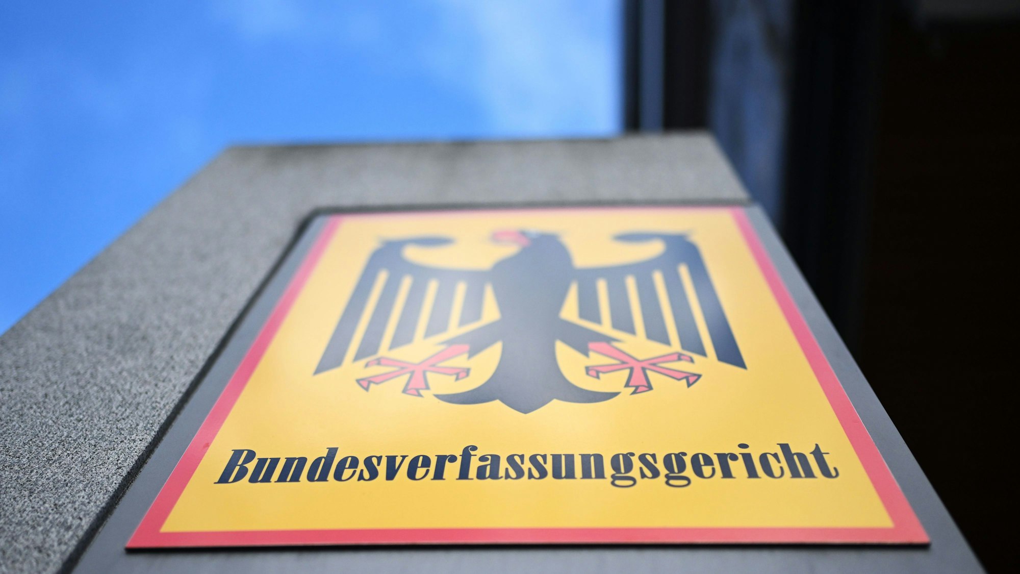 ARCHIV - 15.11.2023, Baden-Württemberg, Karlsruhe: Ein Hinweisschild mit Bundesadler und dem Schriftzug Bundesverfassungsgericht, aufgenommen vor dem Bundesverfassungsgericht. (zu dpa: «Nahaufnahme vom Richter nötig? Kläger scheitern in Karlsruhe») Foto: Uli Deck/dpa +++ dpa-Bildfunk +++