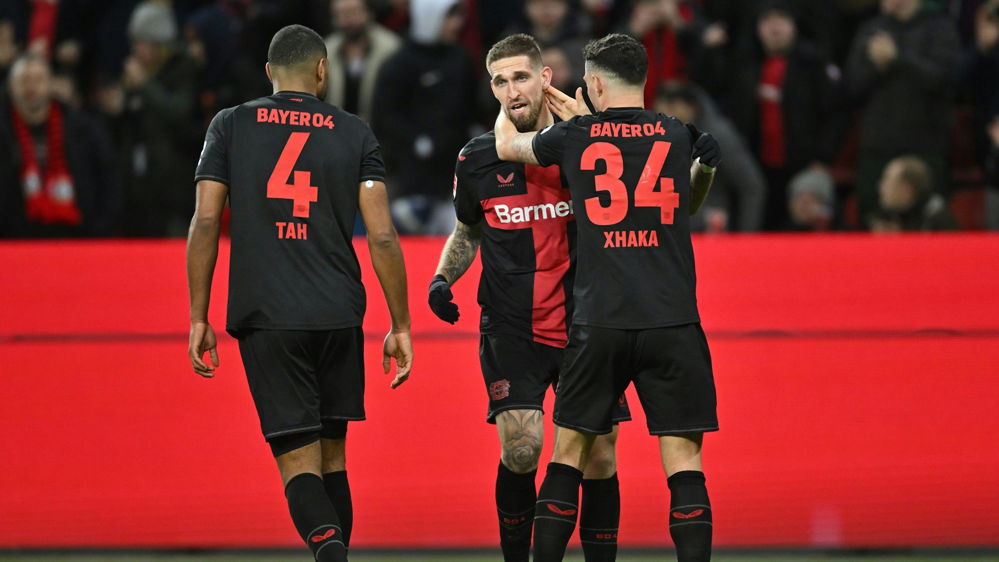 23.02.2024, Nordrhein-Westfalen, Leverkusen: Fußball: Bundesliga, Bayer Leverkusen - FSV Mainz 05, 23. Spieltag in der BayArena, Leverkusens Torschütze Robert Andrich (M) jubelt mit Jonathan Tah (l) und Granit Xhaka über das Tor zum 2:1. WICHTIGER HINWEIS: Gemäß den Vorgaben der DFL Deutsche Fußball Liga bzw. des DFB Deutscher Fußball-Bund ist es untersagt, in dem Stadion und/oder vom Spiel angefertigte Fotoaufnahmen in Form von Sequenzbildern und/oder videoähnlichen Fotostrecken zu verwerten bzw. verwerten zu lassen. Foto: Marius Becker/dpa +++ dpa-Bildfunk +++