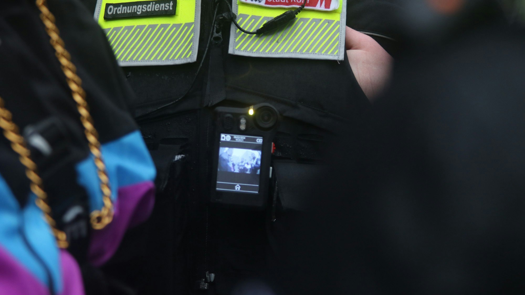 Auf der Weste eines Ordnungsamt-Mitarbeiters befindet sich eine eingeschaltete Bodycam.