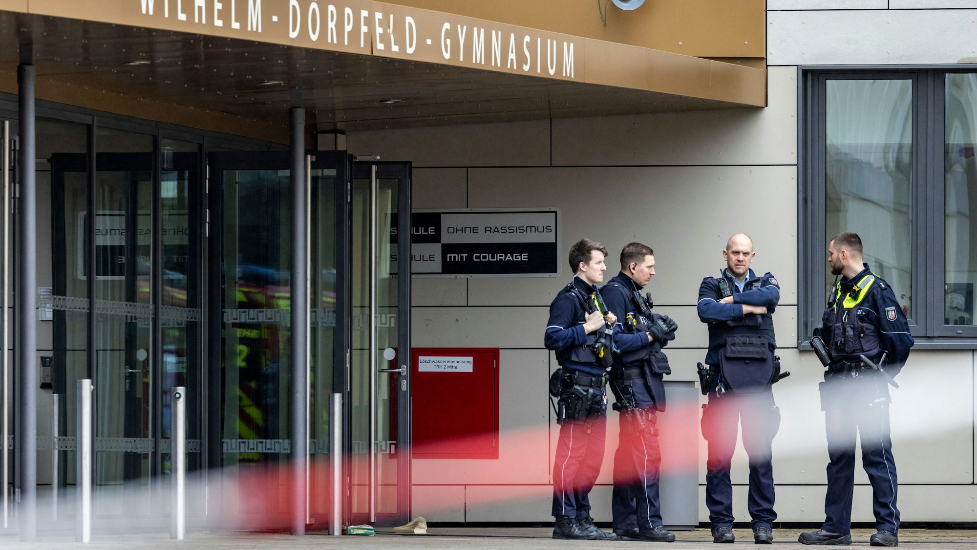 Polizeibeamte stehen vor dem Wilhelm-Dörpfeld-Gymnasium.