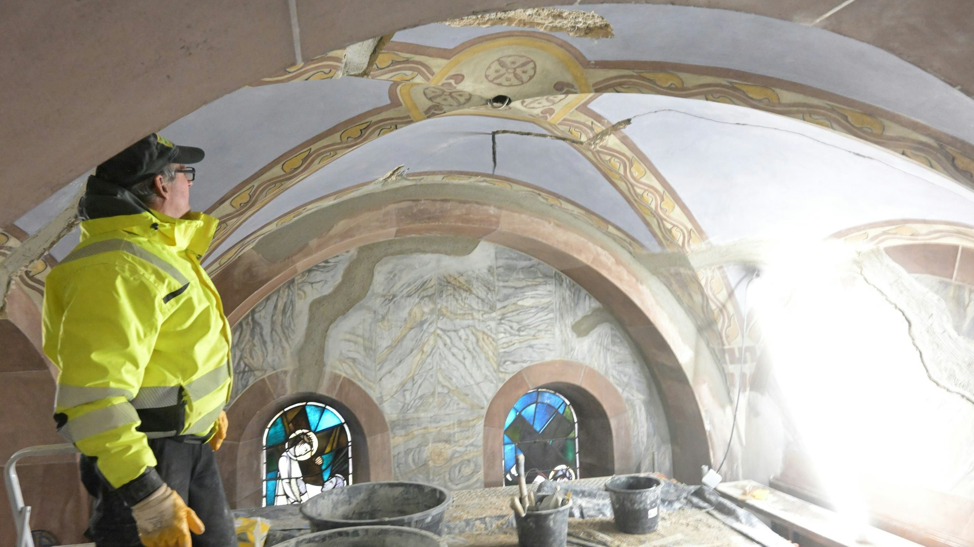 Ein Arbeiter steht in einem Gewölbe der Seitenschiffe von St. Laurentius, das bereits restauriert ist.