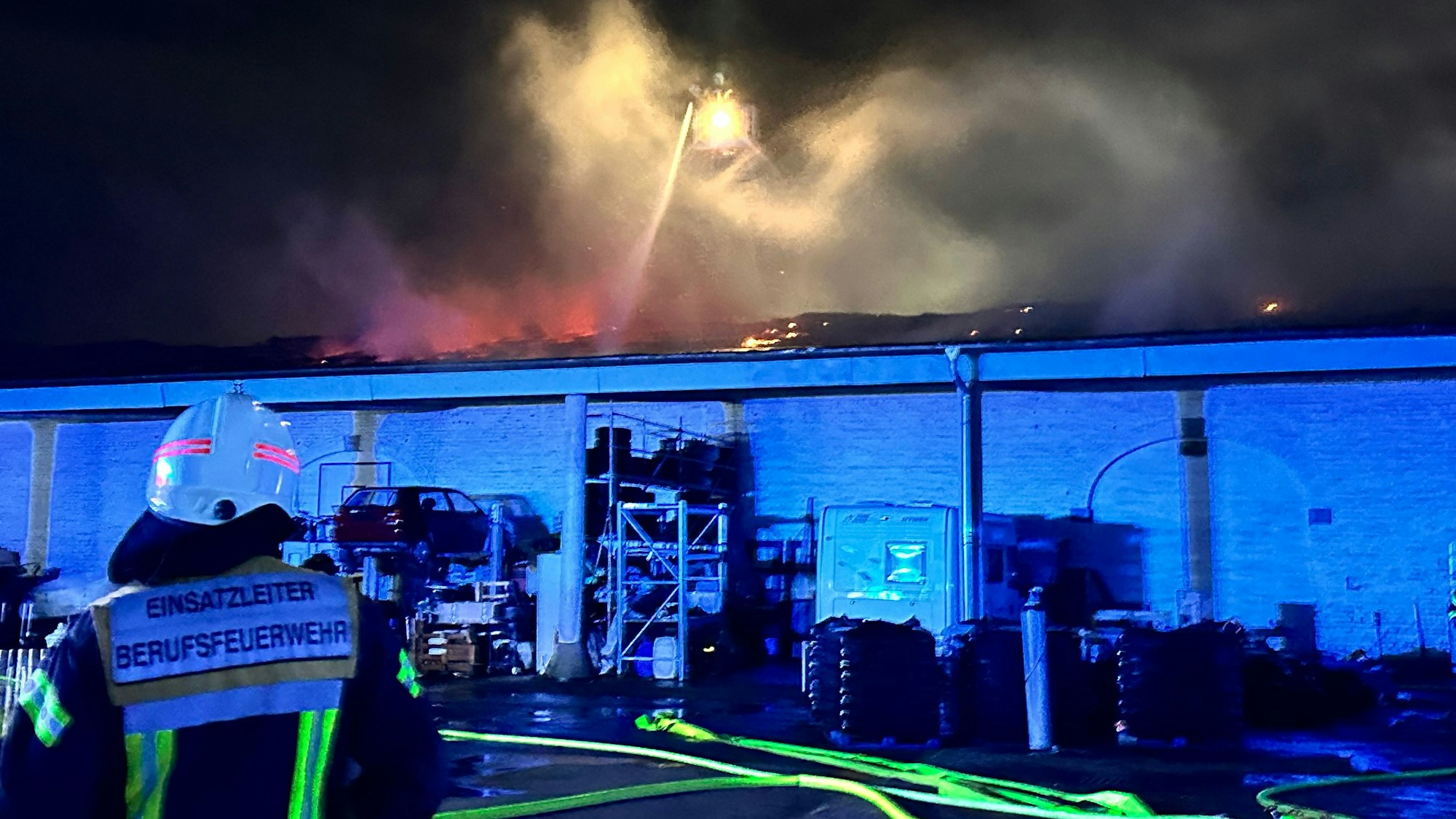 Einsatzkräfte der Feuerwehr löschen einen Brand in Köln-Immendorf.