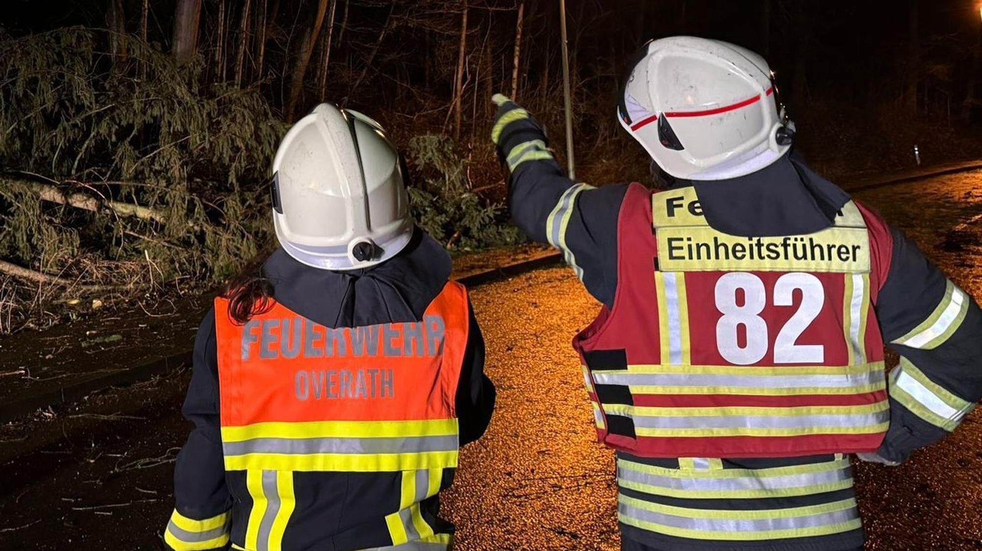 Ein Einheitsführer der Feuerwehr Overath zeigt einer Feuerwehrfrau, was an der Einsatzstelle zu tun ist.