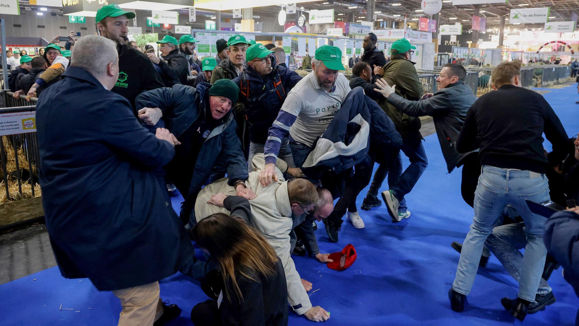Landwirte raufen mit dem Sicherheitspersonal auf der Internationalen Landwirtschaftsmesse, während der französische Präsident Macron die Ausstellung am Eröffnungstag besucht.