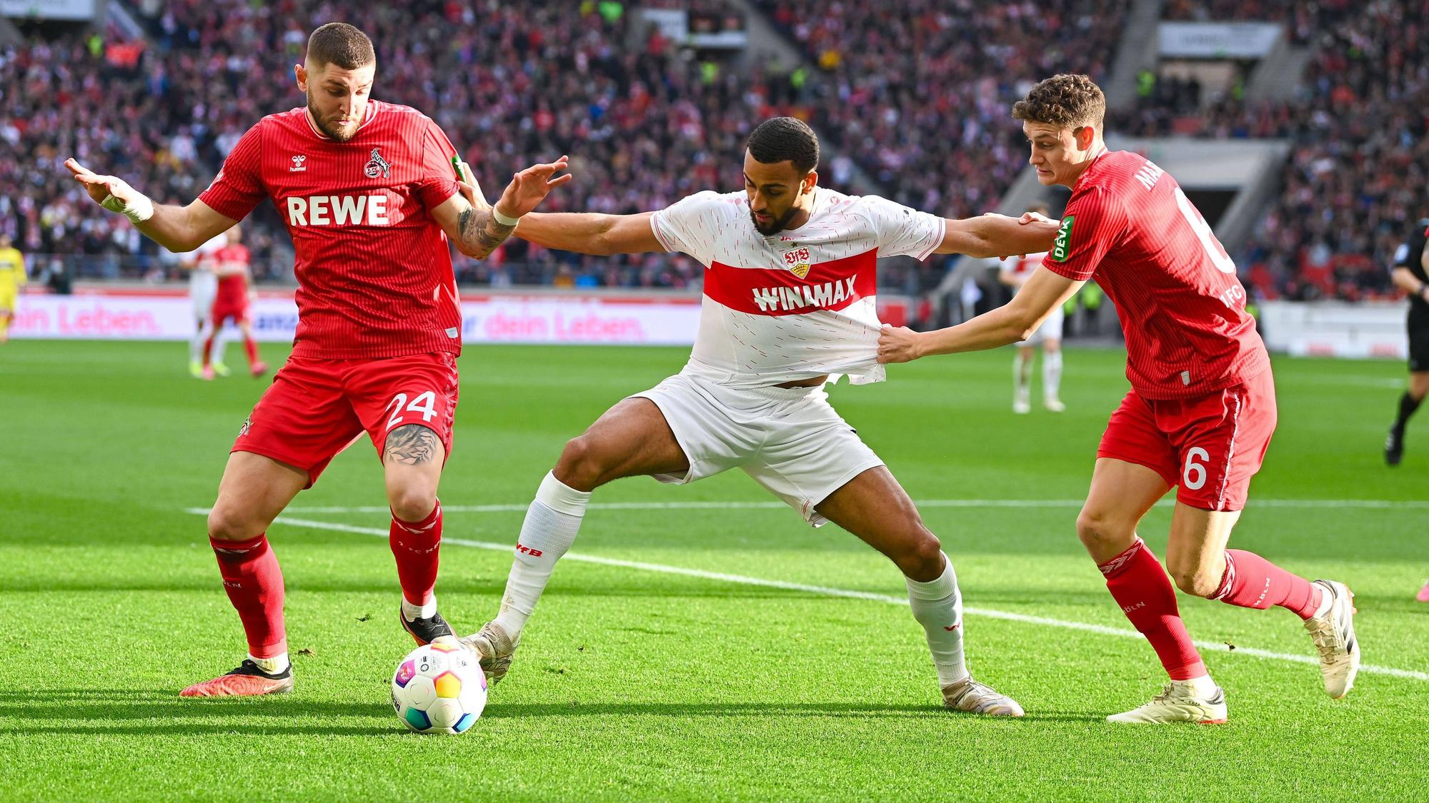 1. FC Köln beim VfB Stuttgart: Abwehrboss Jeff Chabot (l.) und Torschütze Eric Martel nehmen Stuttgarts Josha Vagnoman in die Zange.