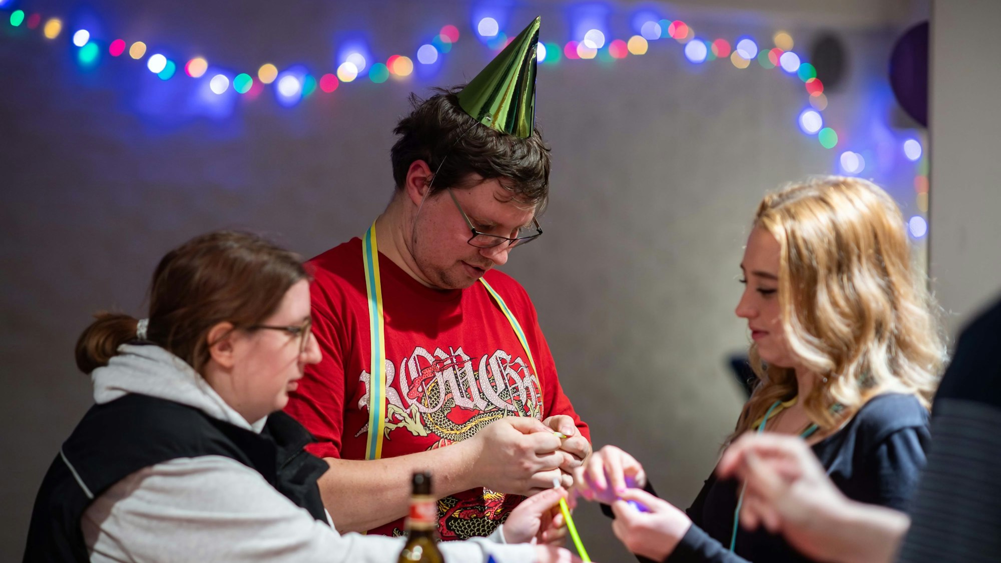 Das Bild zeigt DJ Marco, wie er Anne Engel ein Leuchtband anlegt.