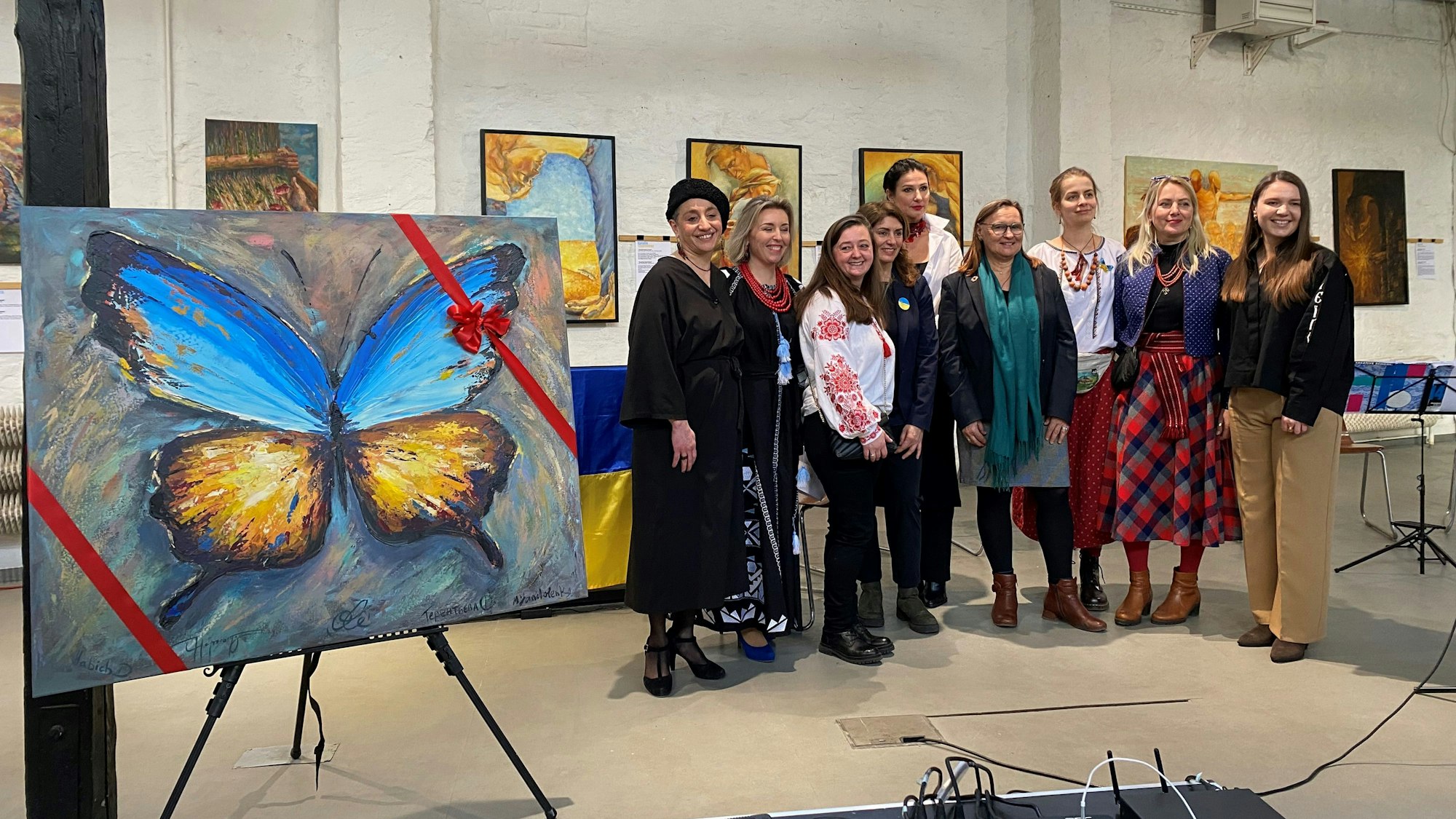 Frauen stehen für ein Foto in einem Atelier voller Bilder zusammen.