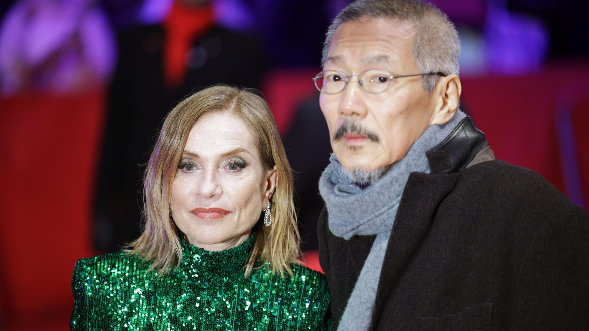 19.02.2024, Berlin: Schauspielerin Isabelle Huppert und Regisseur Hong Sangsoo gehen bei der Weltpremiere des Films "Yeohaengjaui pilyo (A Traveler’s Needs, Sektion Wettbewerb) im Rahmen der Berlinale über den Roten Teppich.