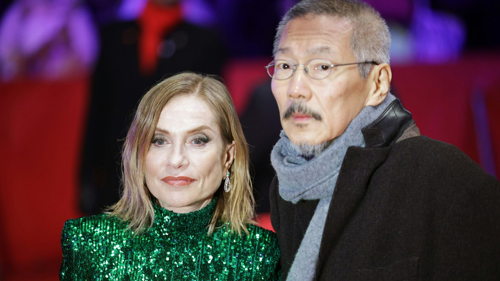 19.02.2024, Berlin: Schauspielerin Isabelle Huppert und Regisseur Hong Sangsoo gehen bei der Weltpremiere des Films "Yeohaengjaui pilyo (A Traveler’s Needs, Sektion Wettbewerb) im Rahmen der Berlinale über den Roten Teppich.