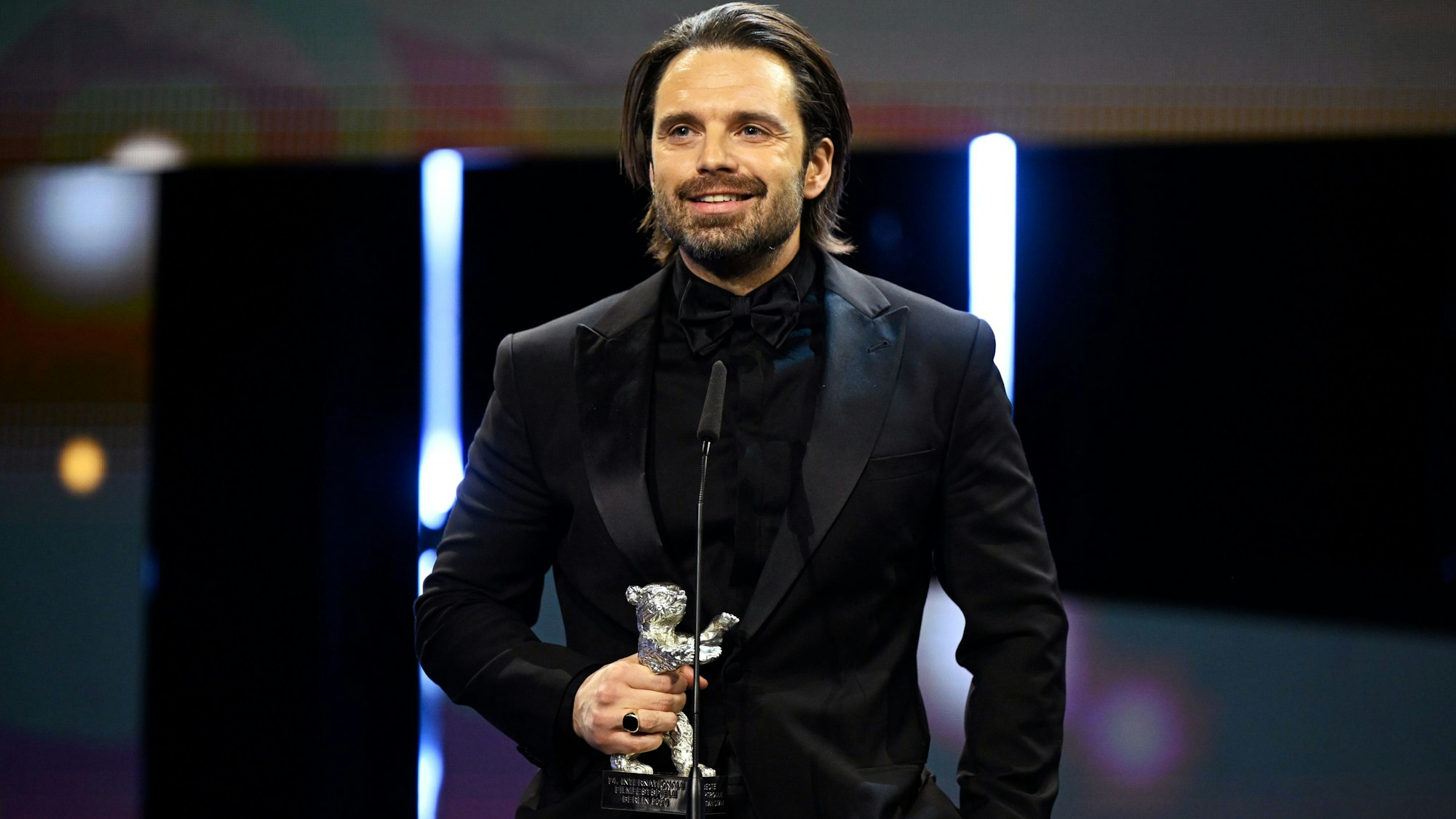 24.02.2024, Berlin: Schauspieler Sebastian Stan steht während der Preisverleihung bei der Abschlussgala im Berlinale Palast auf der Bühne, nachdem er für seine Rolle in "A Different Man" einen Silbernen Bären in der Kategorie Beste schauspielerische Leistung in einer Hauptrolle gewonnen hat.