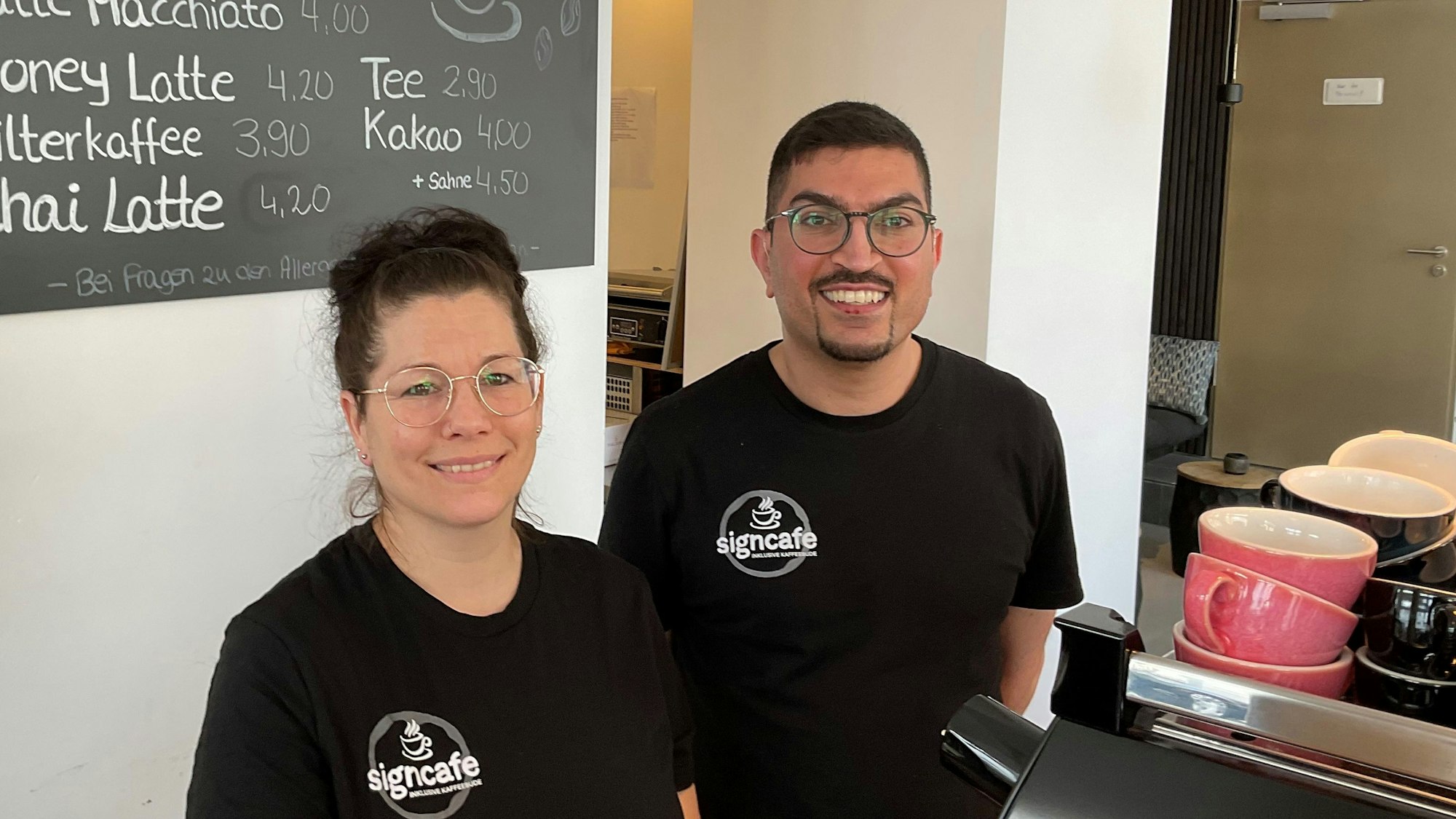 Eine Frau und ein Mann an einer Kaffeemaschine