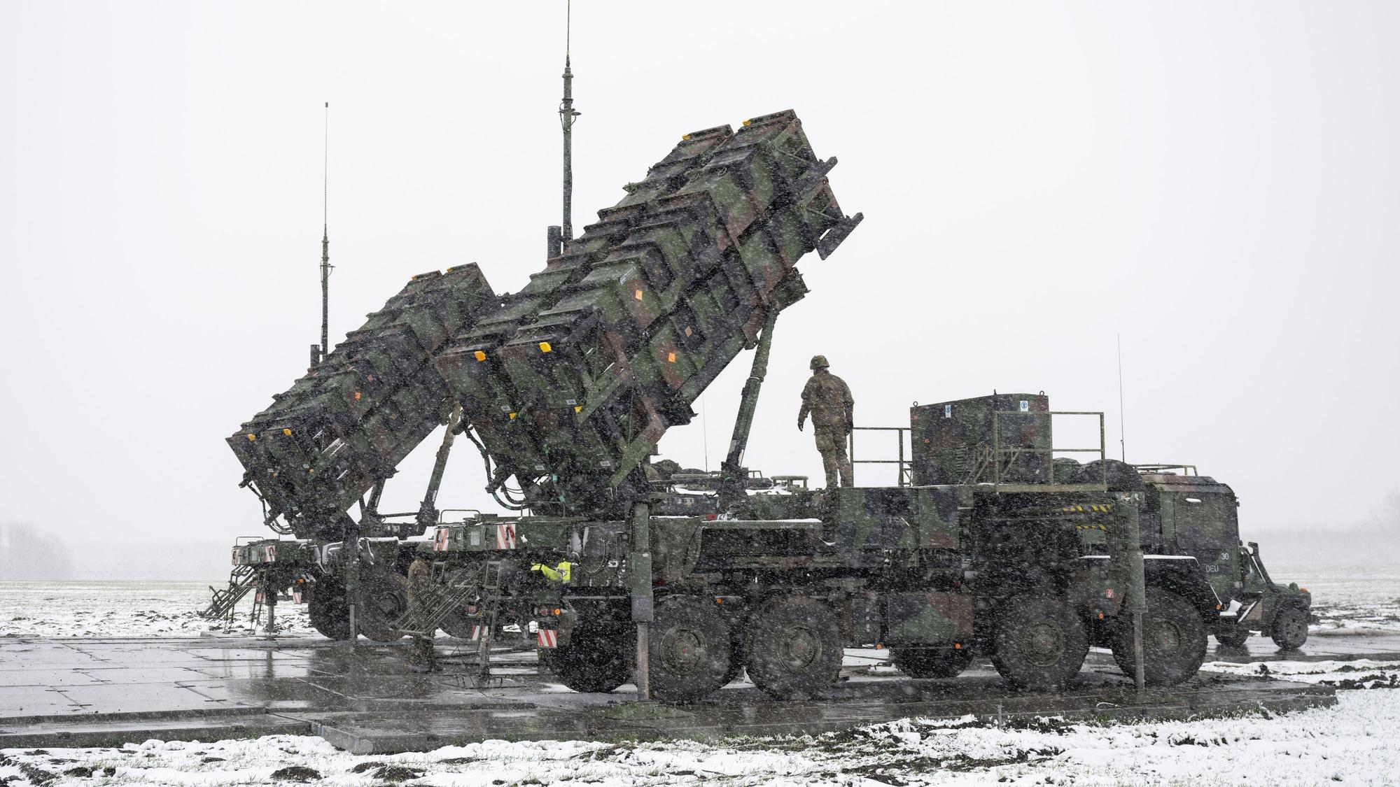 Soldaten der Bundeswehr stehen auf einem Anhänger mit Abschussrampen für Lenkflugkörper des Patriot-Luftabwehrsystems auf einem schneebedeckten Feld im Südosten Polens.