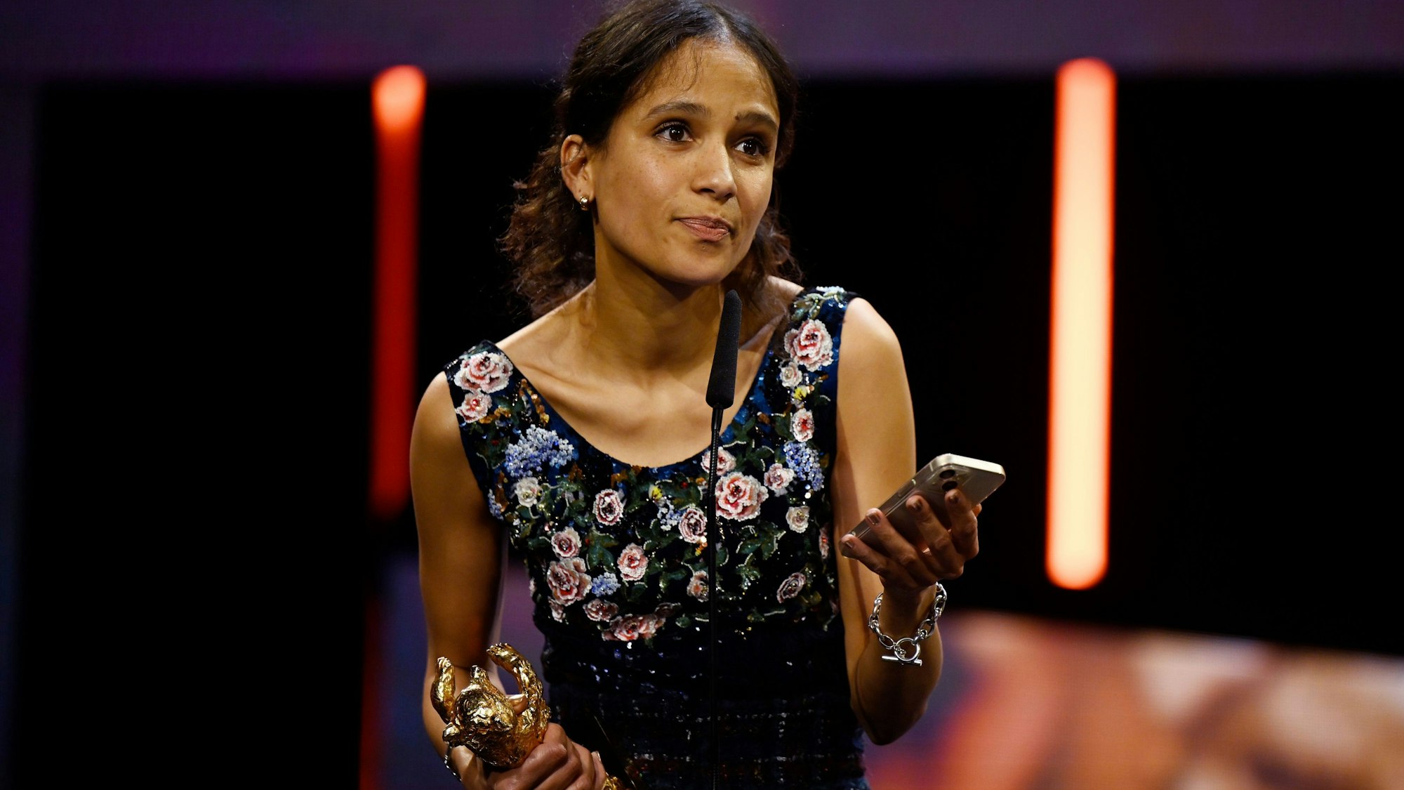 24.02.2024, Berlin: Regisseurin Mati Diop steht während der Preisverleihung bei der Abschlussgala im Berlinale Palast auf der Bühne, nachdem ihr ein Goldener Bär in der Kategorie Bester Film für "Dahomey" überreicht wurde.