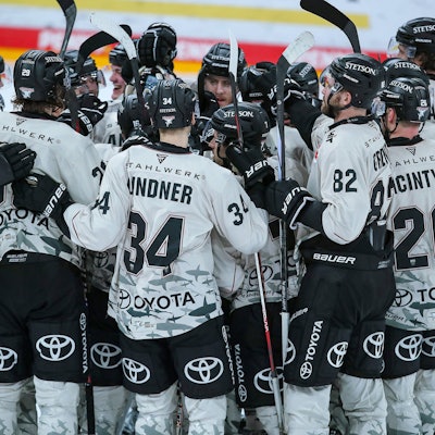 Abschlussjubel nach dem 3:2 Sieg nach Penaltyschießen für die Kölner Haie. Die Mannschaft steht jubelnd auf dem Eis.