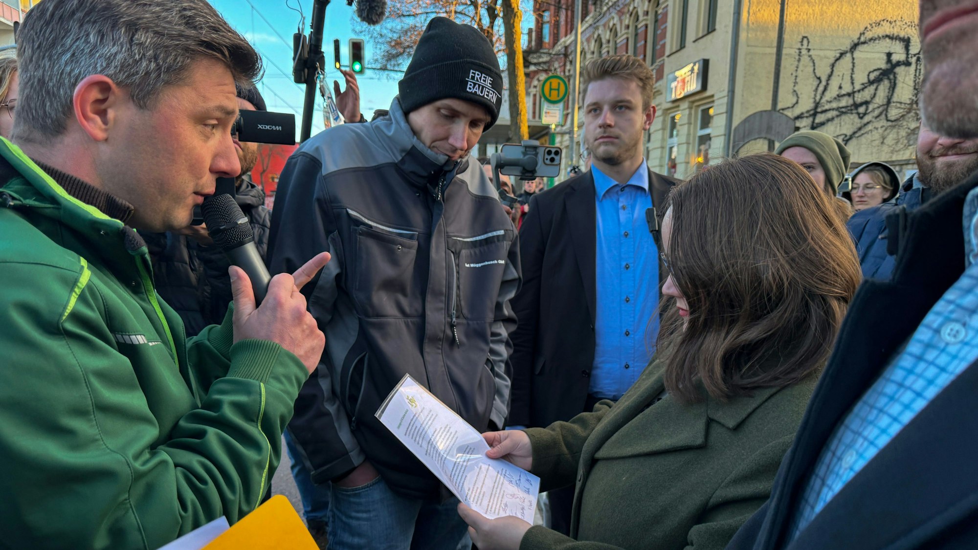Martin Dippe (links), Präsident des Bauernbundes Sachsen-Anhalt, präsentiert der Grünen-Bundesvorsitzenden Ricarda Lang am Samstag seine Forderungen am Rande einer Parteiveranstaltung in Magdeburg.