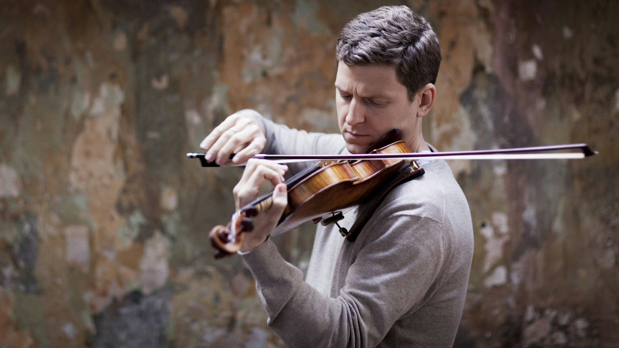 James Ehnes spielt seine Geige. Er trägt einen grauen Pullover.