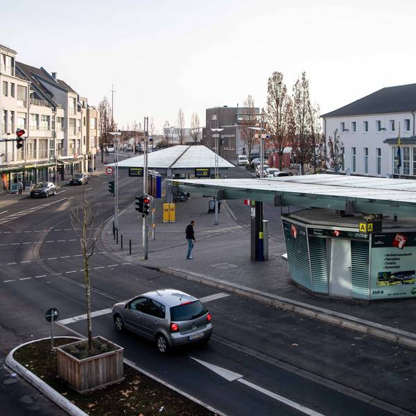 Auf der rechten Seite des Bildes sind der Bahnhofsvorplatz und ein Teil des Bahnhofsgebäudes in Euskirchen zu sehen.