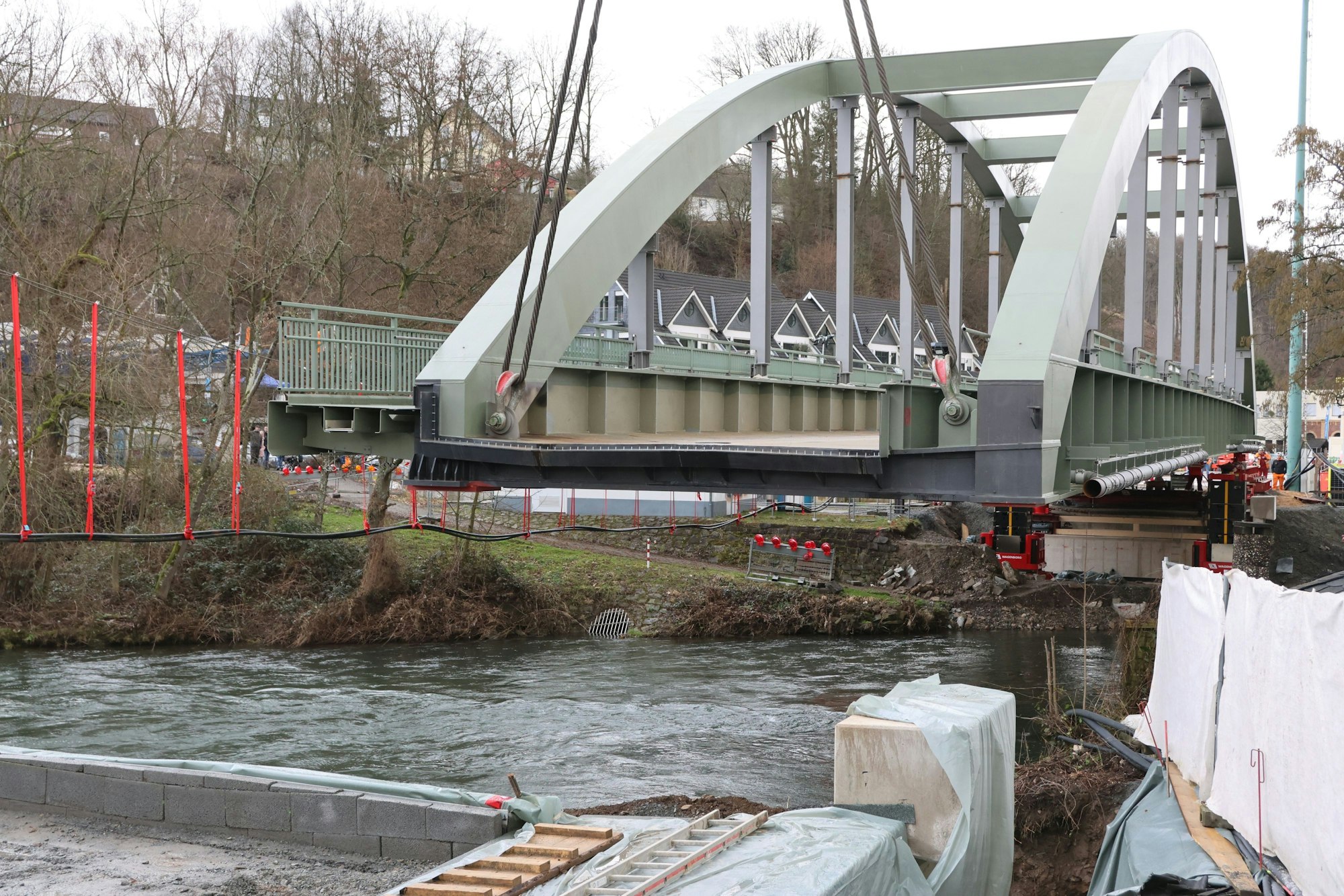 Eine Brücke hängt an Tauen über einem Fluss.