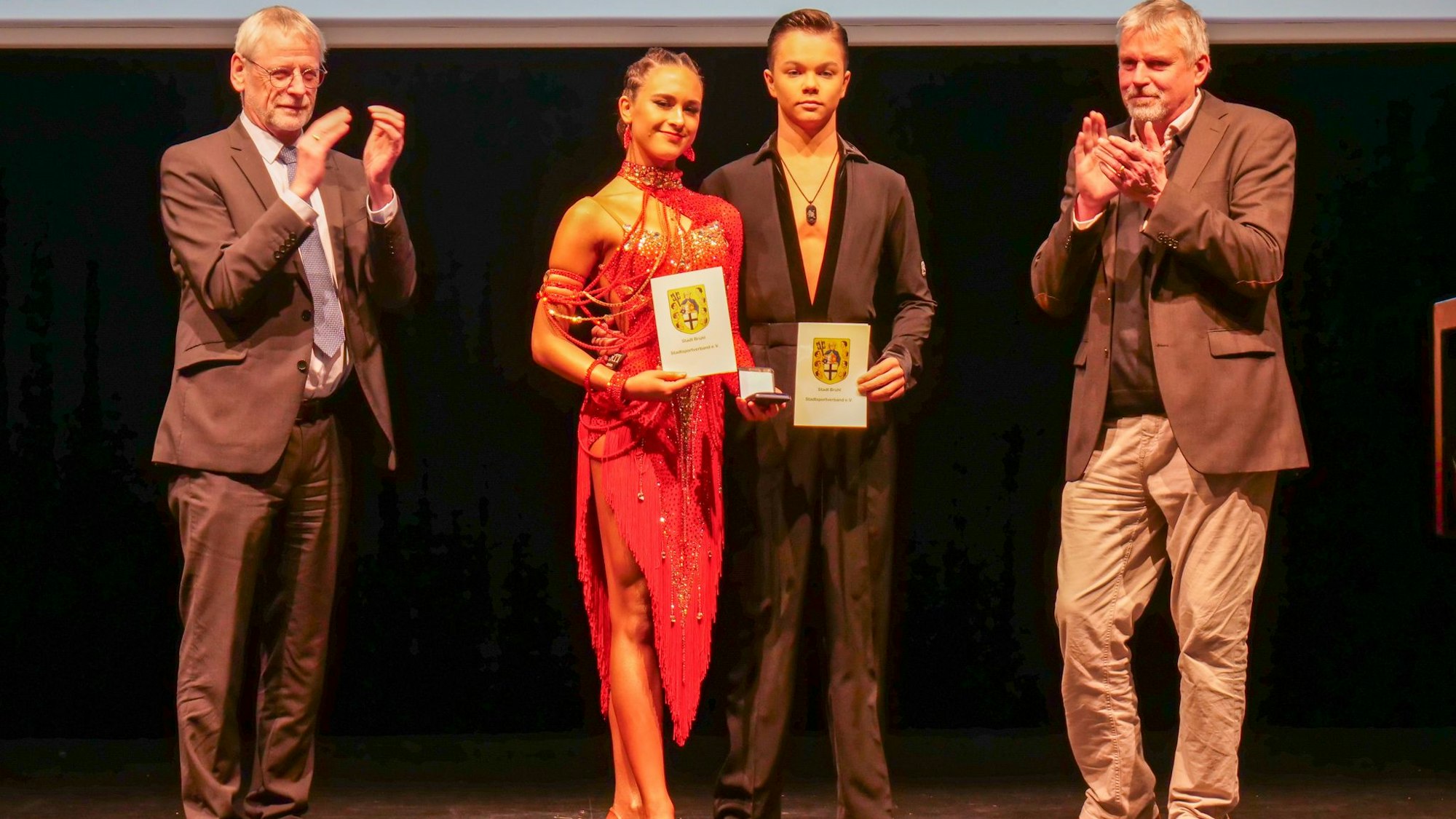 Auf dem Bild ist ein Tanzsportpaar zu sehen, das ausgezeichnet wurde.