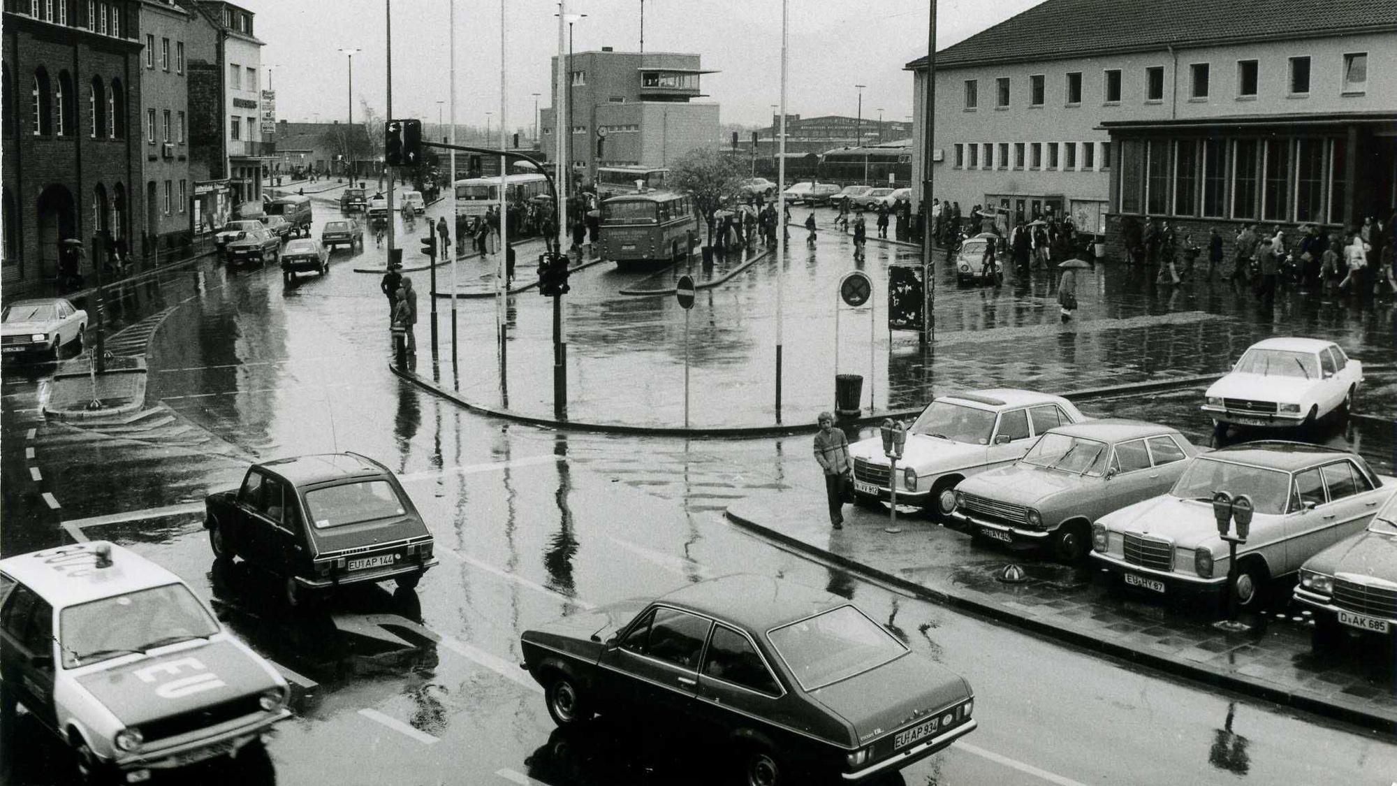 Das Bild zeigt den Vorplatz des Bahnhofs. Im Vordergrund fährt ein Polizeiauto.